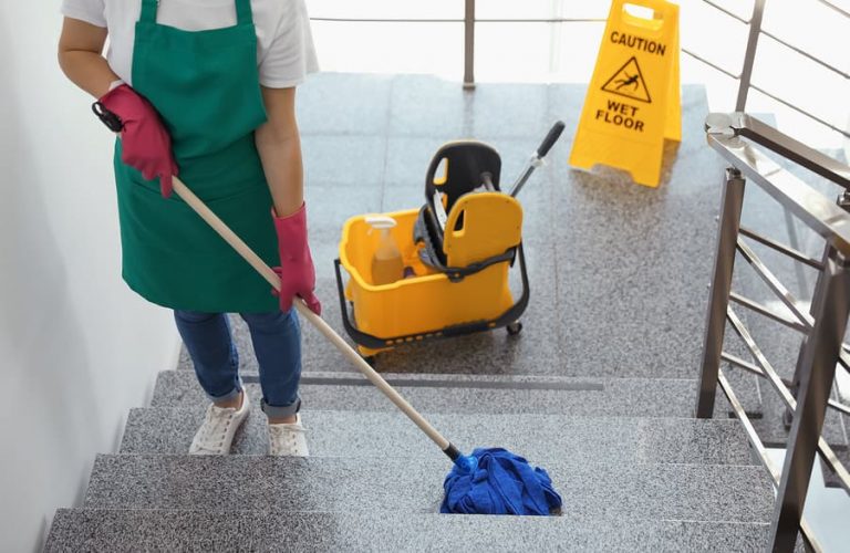 a janitor mopping a staircase of a building