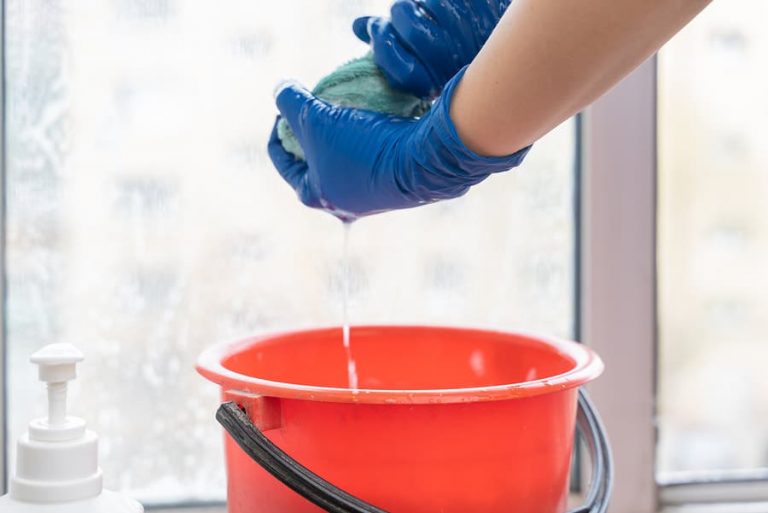 A picture of a towel being squeezed to extract water from cleaning a window
