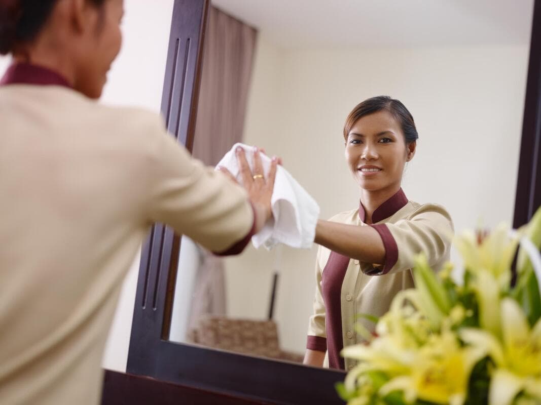 A picture of a woman wiping a mirror