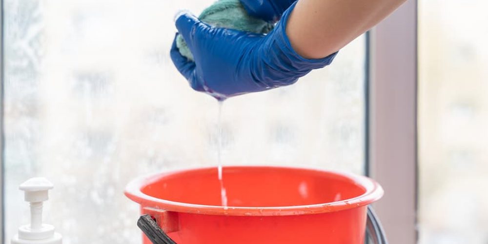 A picture of a towel being squeezed to extract water from cleaning a window